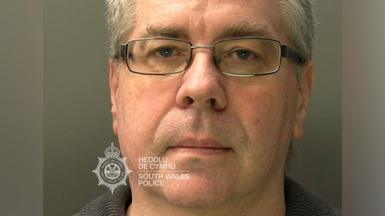 A mugshot of Christopher Phillips, who has grey hair and glasses