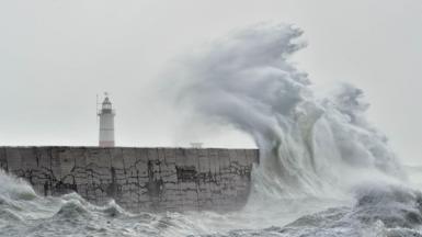 Large waves crashing on Newhaven Breakwater Light at Newhaven Harbour, East Sussex