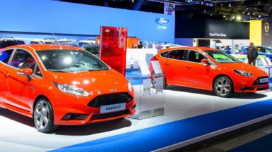 Two bright red Ford Fiestas at a car show