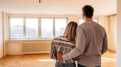 Couple looking round a house with no furniture in it