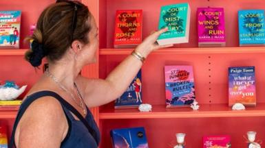 A customer looks at romance novels books in a west London bookshop