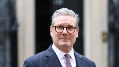 A headshot of Keir Starmer outside No.10 Downing Street. He is looking at the camera