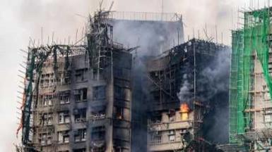 Buildings are burned and smoke rises from them.