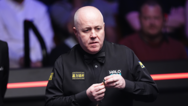 John Higgins chalks his cue