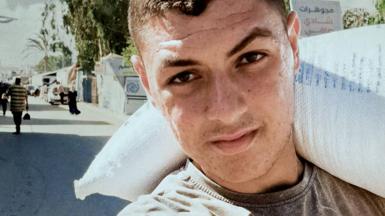 A close up picture of Mosab appearing to show him carrying a bag