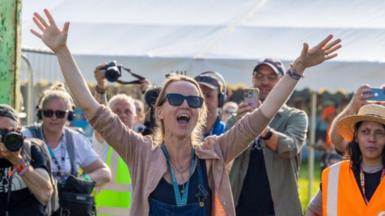 Emily Eavis shouts a greeting to festivalgoers as she opens the gates to Glastonbury