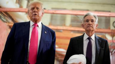 Donald Trump appears next to Jerome Powell, who is carrying a white hard hat, during a visit to the Federal Reserve building as it undergoes renovations.