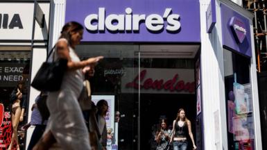 Several women walk outside a Claire's accessories store on a sunny day