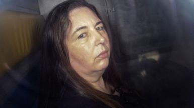 Erin Patterson, looking at the camera in the back of a prison van