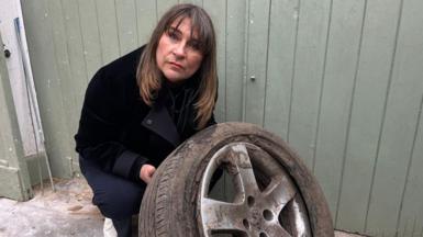 Sarah Gray holding a burst tyre