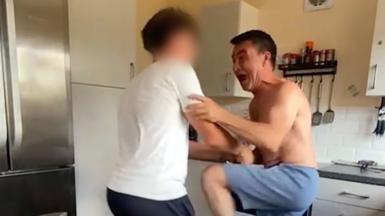 Man screams in joy with one hand on his son's arm.