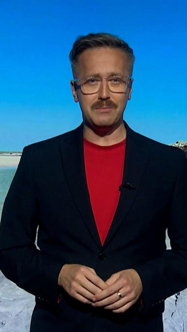 Man with red top and glasses on with blazer