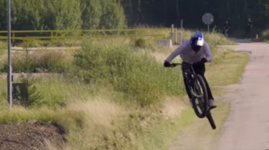 A man on a mountain bike is flying through the air as he makes his way through a truck with an empty load