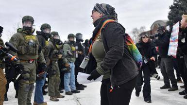 A protester (centre) shouts towards a line of federal law enforcement agents during an anti-ICE demonstration outside the Bishop Whipple Federal Building in Minneapolis, Minnesota