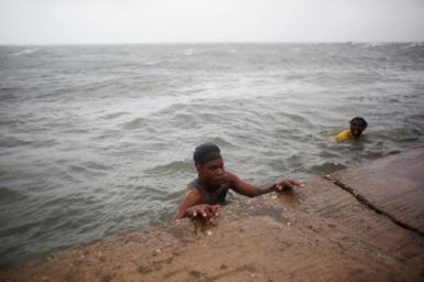 People swim in the water, as Hurricane Melissa approaches, in Kingston, Jamaica