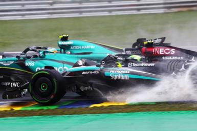 Spray comes up from Lewis Hamilton's Mercedes as he attempts to pass Aston Martin's Fernando Alonso during the 2024 Sao Paulo Grand Prix