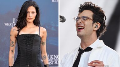 Gabbriette Bechtel on the left wears a black corset and has several tattoos on her arms. Matty Healy, right, performs on stage wearing a white lab coat and glasses. 