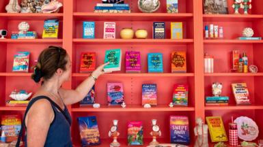 A customer looks at romance novels books in a west London bookshop