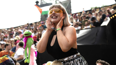 Woman in festival crowd wearing sunglasses