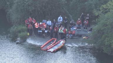 Search and rescue teams at the side of a pond