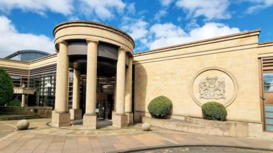 Glasgow High Court - a sandstone building with columns at the front forming a curcular entrance 