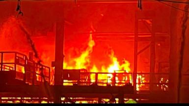 Close up image showing a large fire burning tn the steelworks with large yellow flames. 