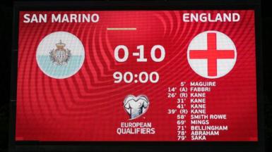 A scoreboard shows San Marino 0-10 England