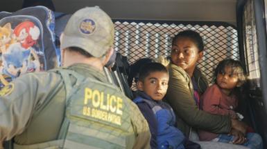 Migrants detained by US border patrol officers at the US border
