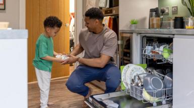 Father and son load the dishwasher together