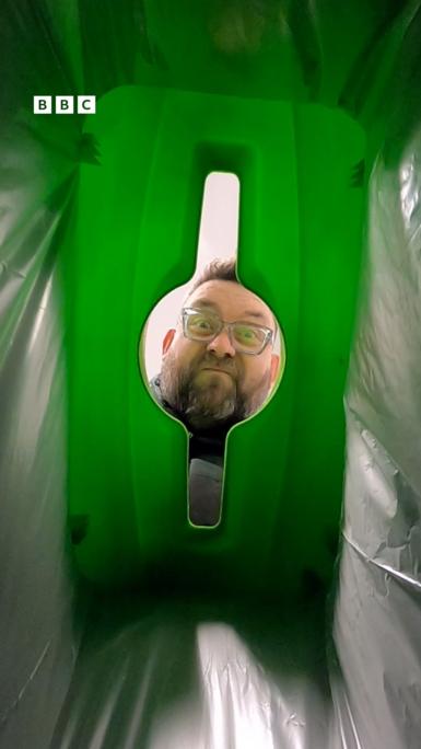 A man looks into a bin