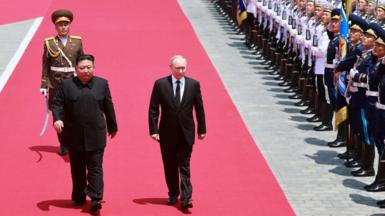 Kim Jong Un and Vladimir Putin walking on red carpet