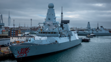 A handout image of the British warship HMS Dragon floating at sea against he backdrop of a sunset
