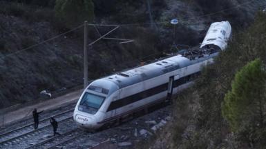 Members of the Spanish Civil Guard work next to one of the trains involved in the accident