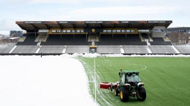 Snow is cleared off the Bodo/Glimt pitch