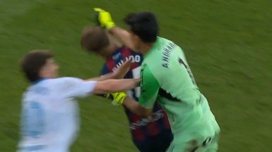 Real Zaragoza goalkeeper Esteban Andrada punches Huesca captain Jorge Pulido