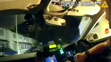 An officer is holding the wheel as a van reverses into the side of the police car