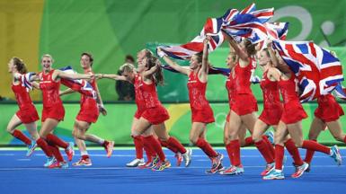 Team GB hockey players run with Union Jacks as they celebrate their hockey gold in 2016