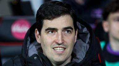 Bournemouth manager Andoni Iraola smiles as he watches a match