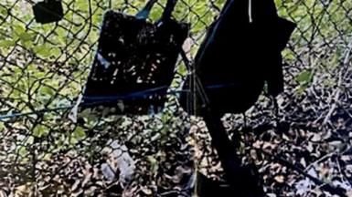 A photo shows  the rifle and other items, that look like bags hanging on a fence, found near where a suspect was discovered during a press conference regarding an apparent assassination attempt of former President Donald Trump on September 15, 2024, in West Palm Beach