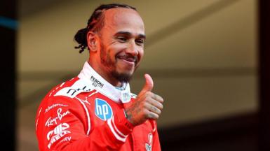 Lewis Hamilton gives a thumbs-up on the Monaco podium 
