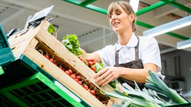 Woman sorting vegetables in a supermarket or shop