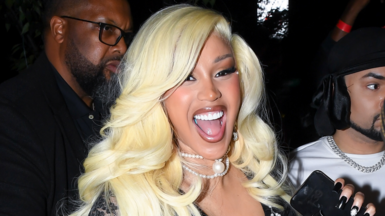 Cardi B smiling in a blonde wig