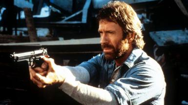 Chuck Norris points a gun in a scene from the film Hero And The Terror in 1988