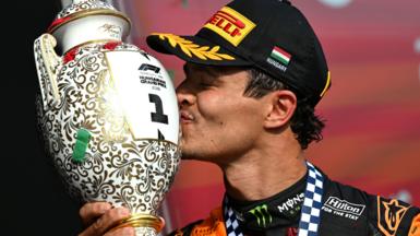 McLaren's Lando Norris kisses the winner's trophy on the podium at the Hungarian Grand Prix