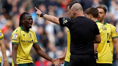 Wrexham's Issa Kabore (left) protests with referee Robert Madley