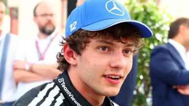 Kimi Antonelli, wearing a Mercedes cap, smiles after taking pole position for the Monaco Grand Prix