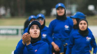 Nahida Sapan catches a ball, watched on by her Afghan women team-mates