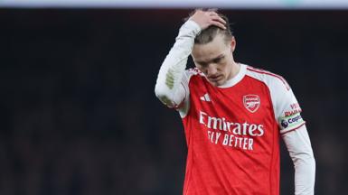 Arsenal captain Martin Odegaard runs his hand through his hair and looks disappointed