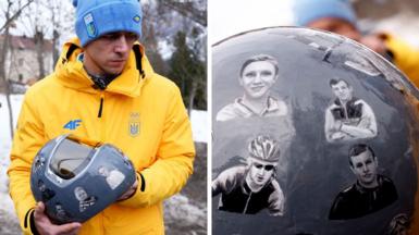 Ukraine's skeleton racer Vladyslav Heraskevych holds his helmet, which depicts victims of his country's war with Russia,