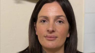 A women with brown hair looking directly at the camera